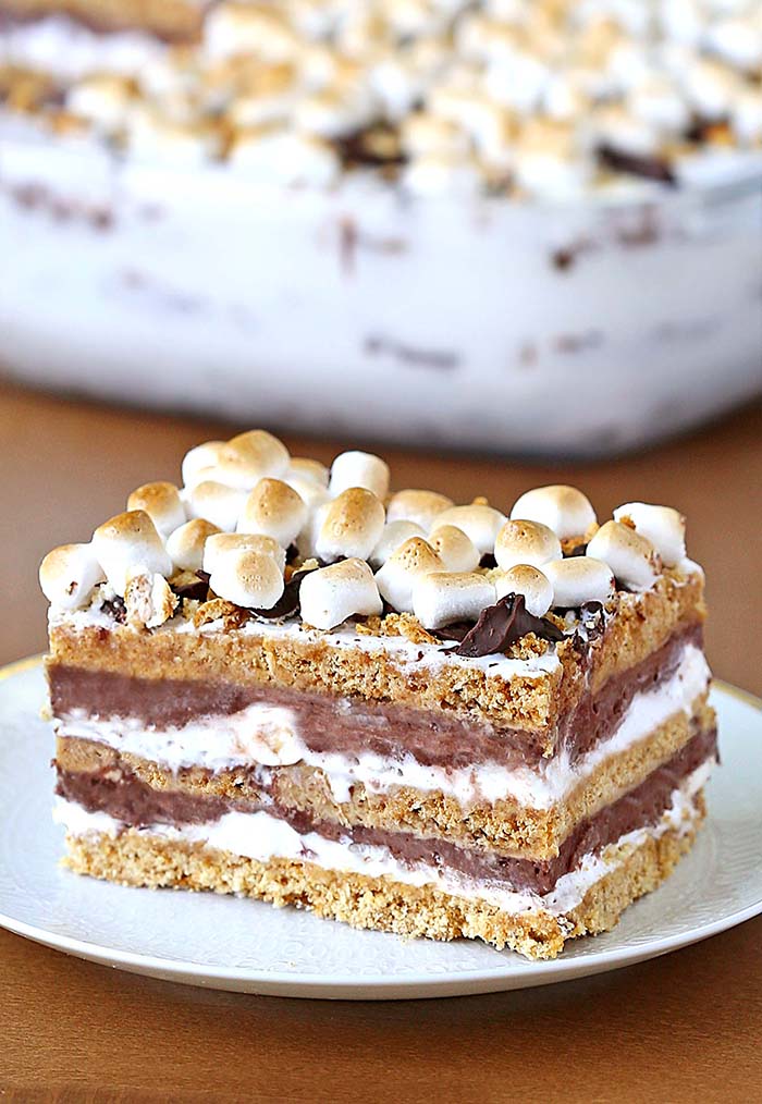 All the flavors of real s’mores are incorporated into one amazing cake! S’mores Icebox Cake with layers of decadent chocolate ganache, marshmallow creme  and cake-like graham crackers.