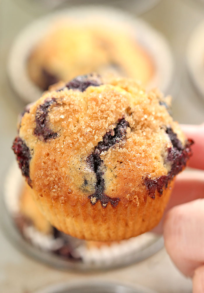 The best blueberry muffins recipe! Bursting with blueberries, moist and fluffy with amazing scent of almond and vanilla, covered with crunchy cinnamon sugar.