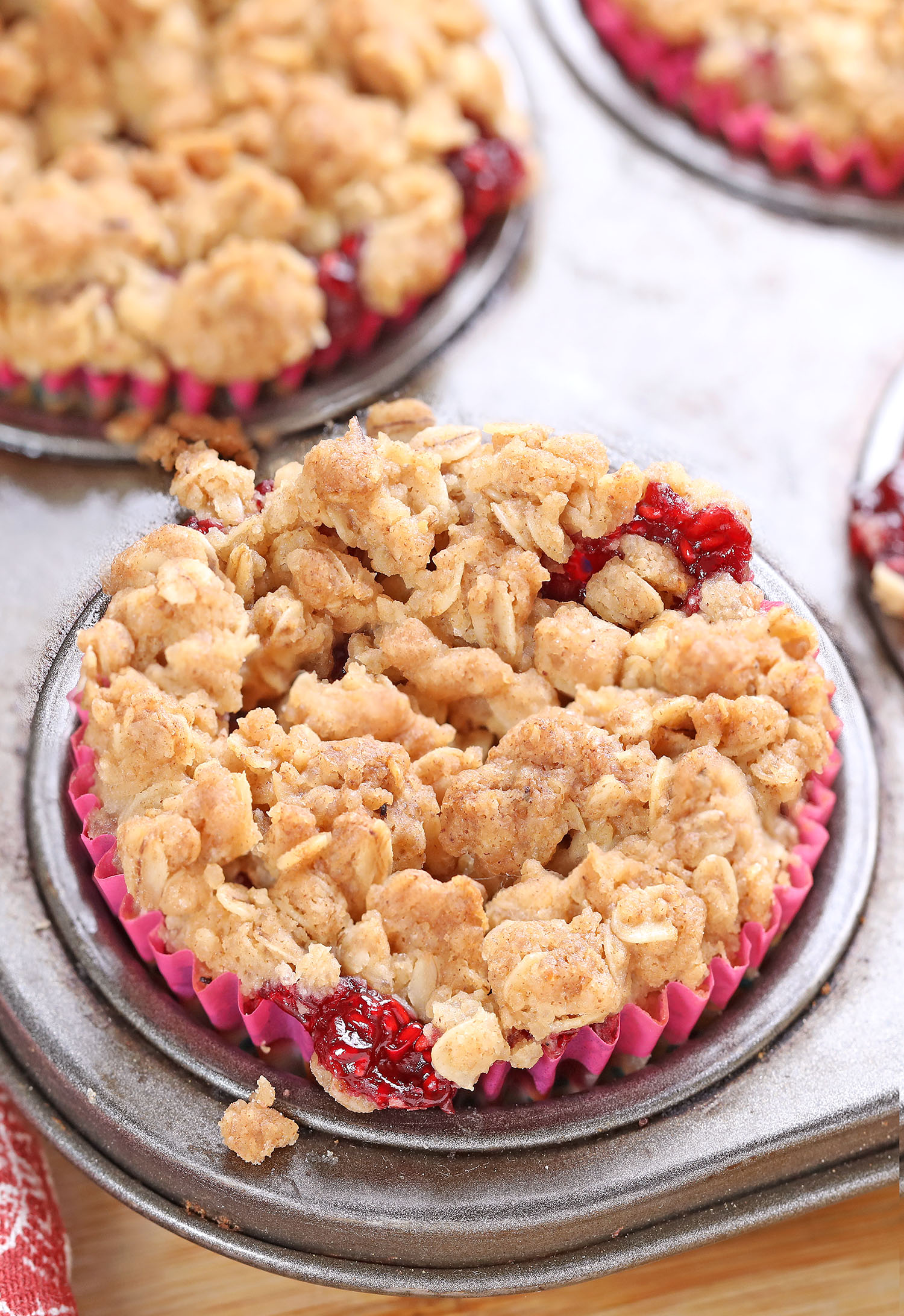 Raspberry Crumble Mini Cheesecake - The BEST easy summer dessert! A layer of a graham cracker crust, creamy cheesecake, juicy, sticky, bubbly raspberries, and topped with a buttery crumble that’s baked to perfection.