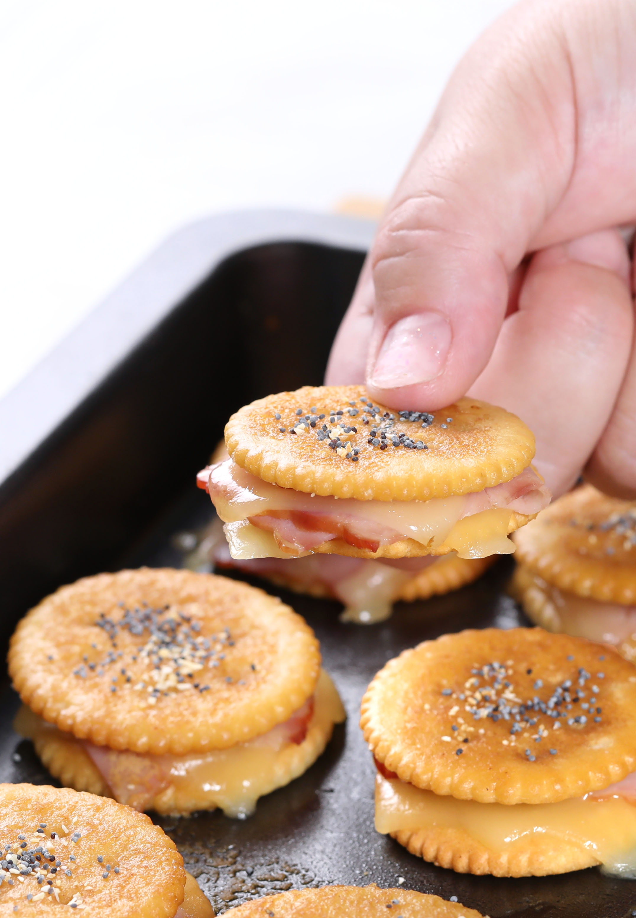 Ham and Cheese Ritz Cracker Sandwiches – fun little treats to serve for Christmas appetizers or game day snacking. Always a crowd favorite with layers of black forest Ham and Swiss cheese sandwiched in buttery crackers then topped with a sensational dijon glaze!