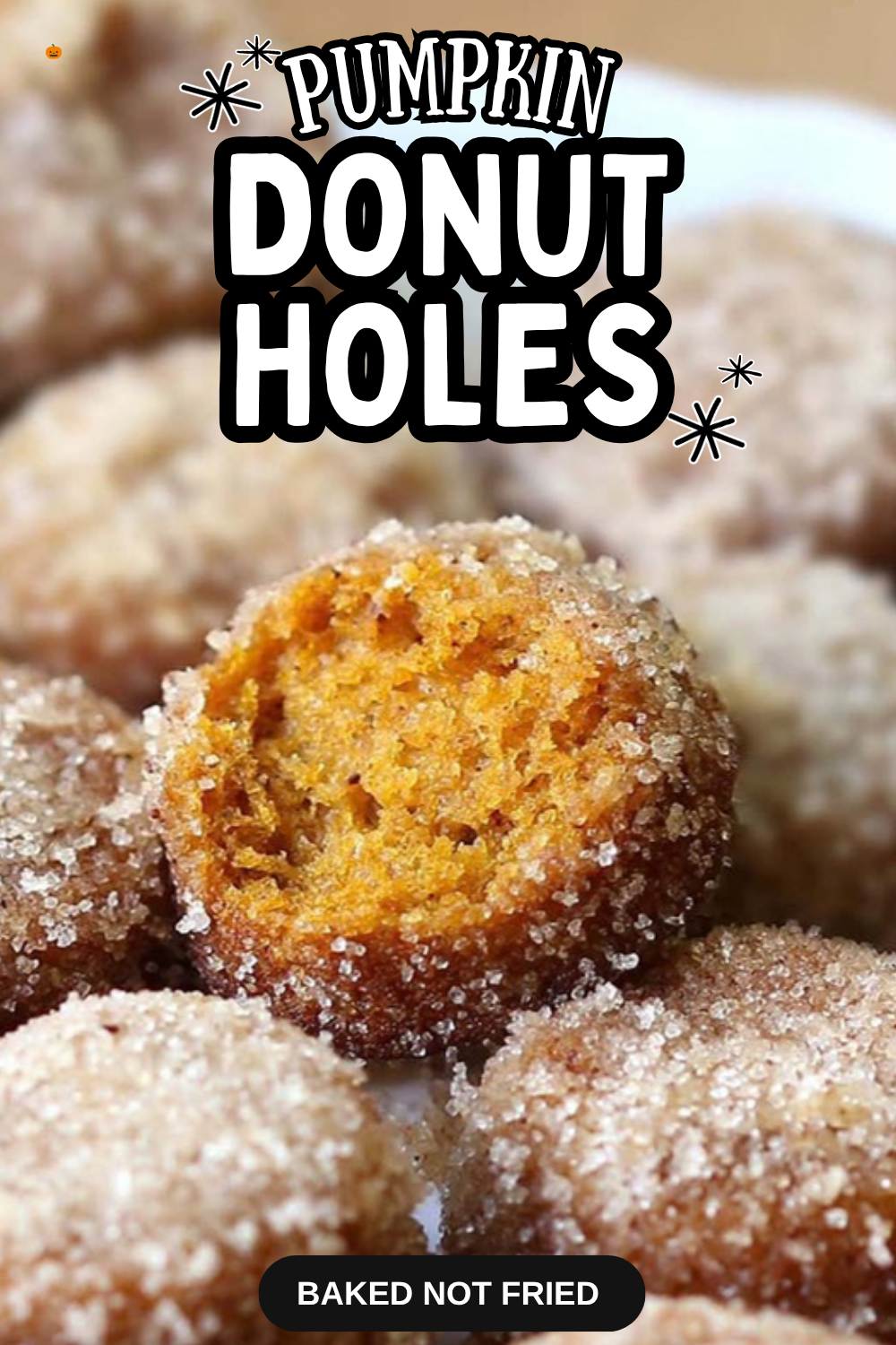 Baked pumpkin donut holes rolled in cinnamon sugar, one bitten open